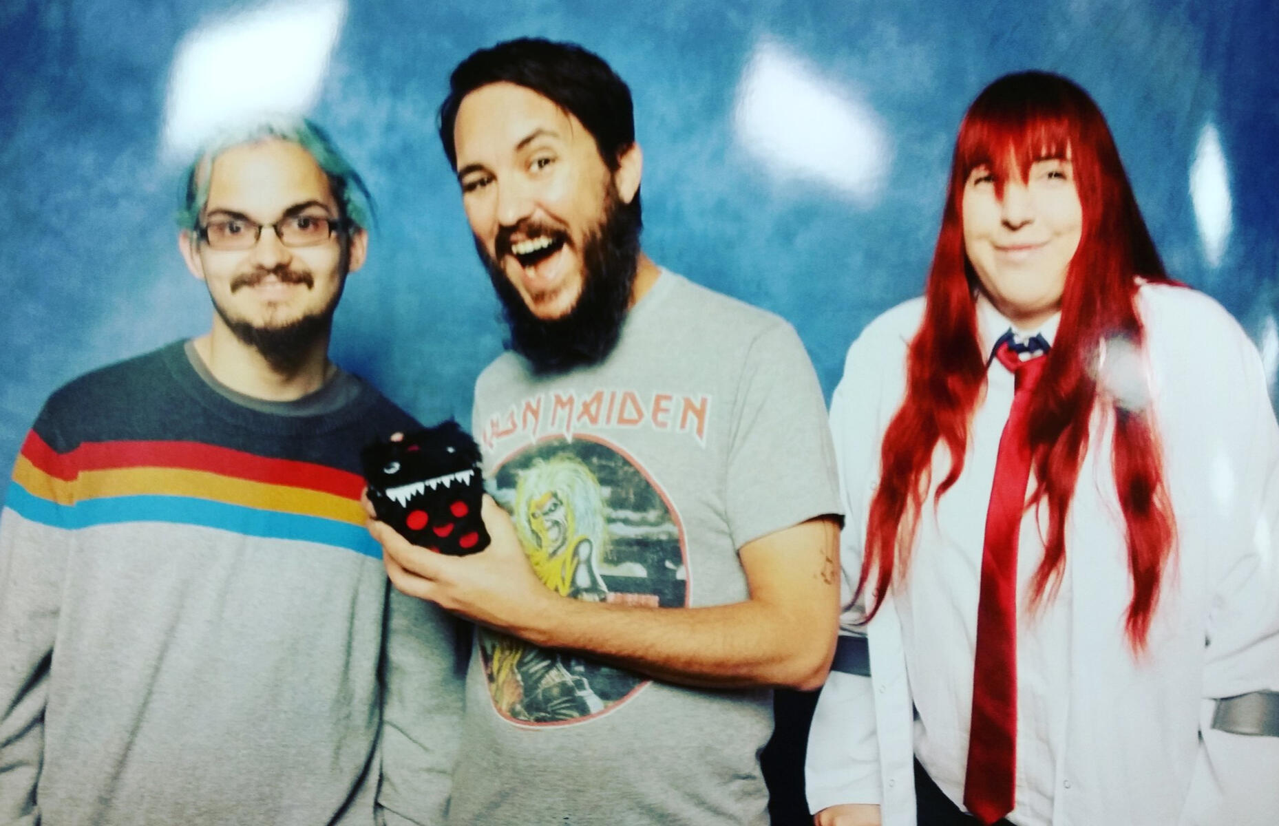 Two people in cosplay stood either side of actor Wil Wheaton